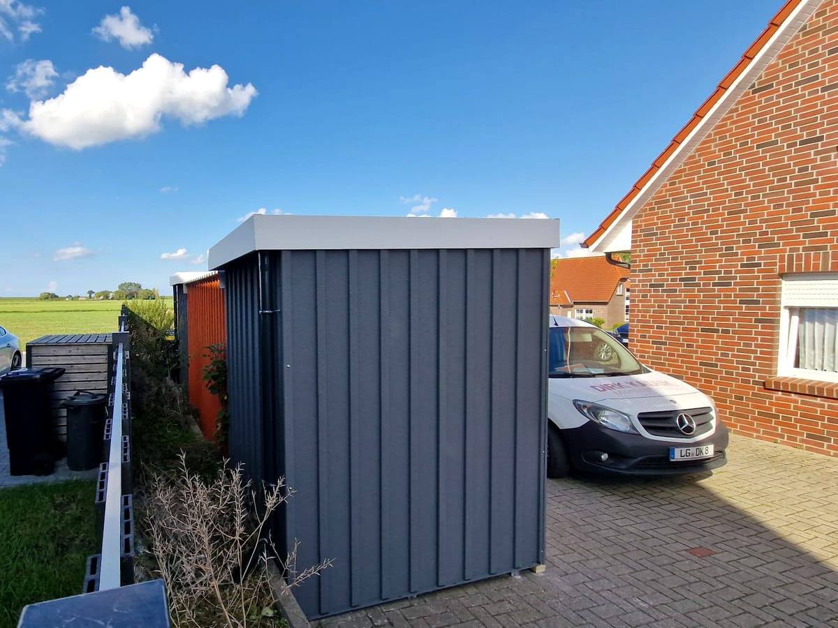 Kleines Gerätehaus aus Metall in der Einfahrt