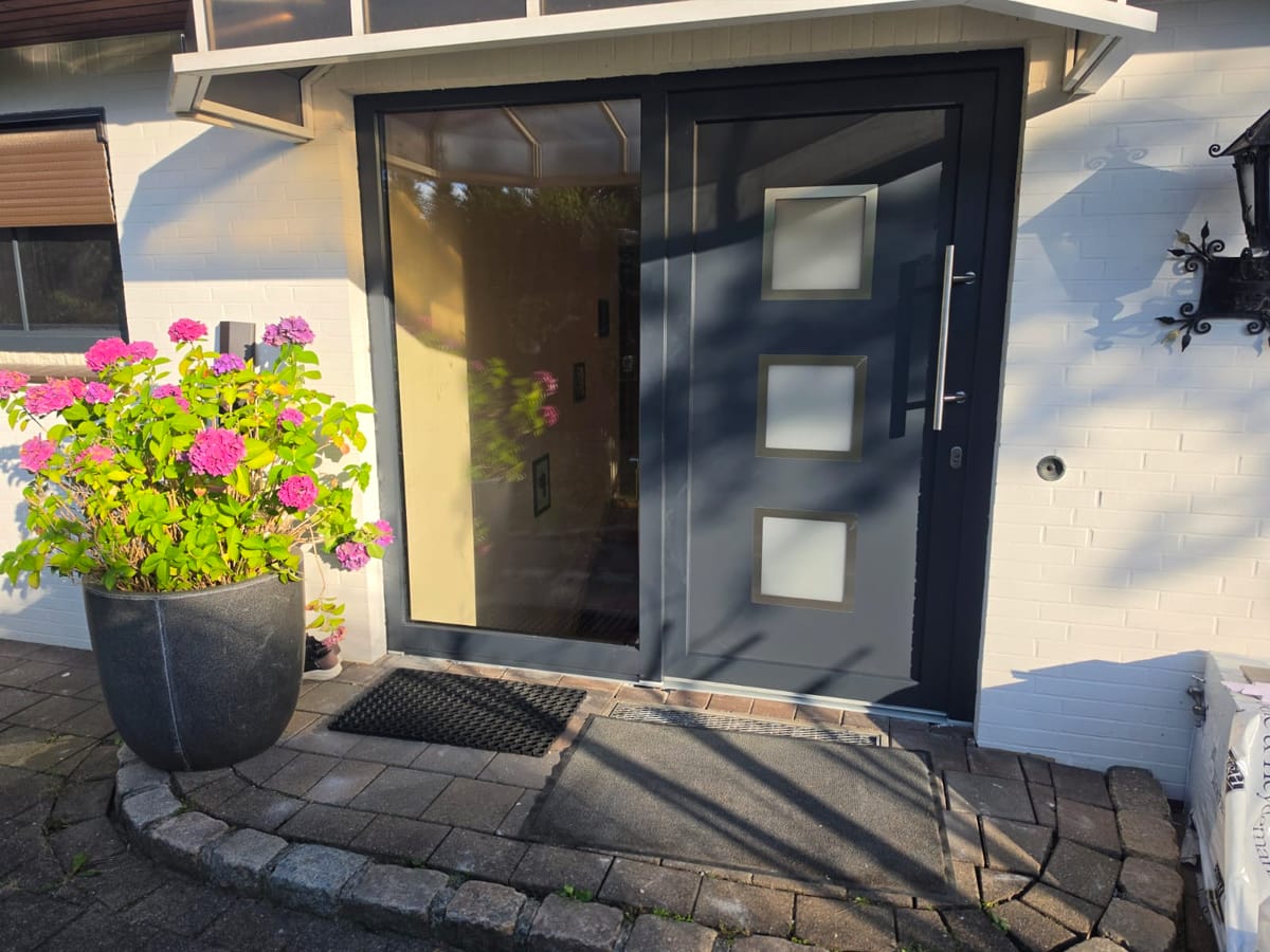 Anthrazitfarbene Haustür mit Glasausschnitten und Vordach, montiert von H&M Montageservice